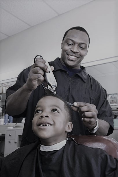 Barber giving kid a haircut